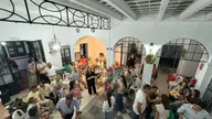 Grupo de personas de distintas edades compartiendo en un patio con sillas y guitarras en una convivencia festiva y animada en Badajoz