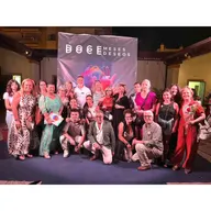 Grupo de personas posando sonrientes frente a un cartel que dice doce meses doce deseos en un evento benéfico en Jerez